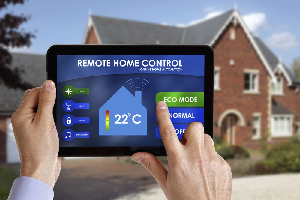 Smart Home Control: Person Holding Tablet with 'Remote Control Home' Interface in Front of House