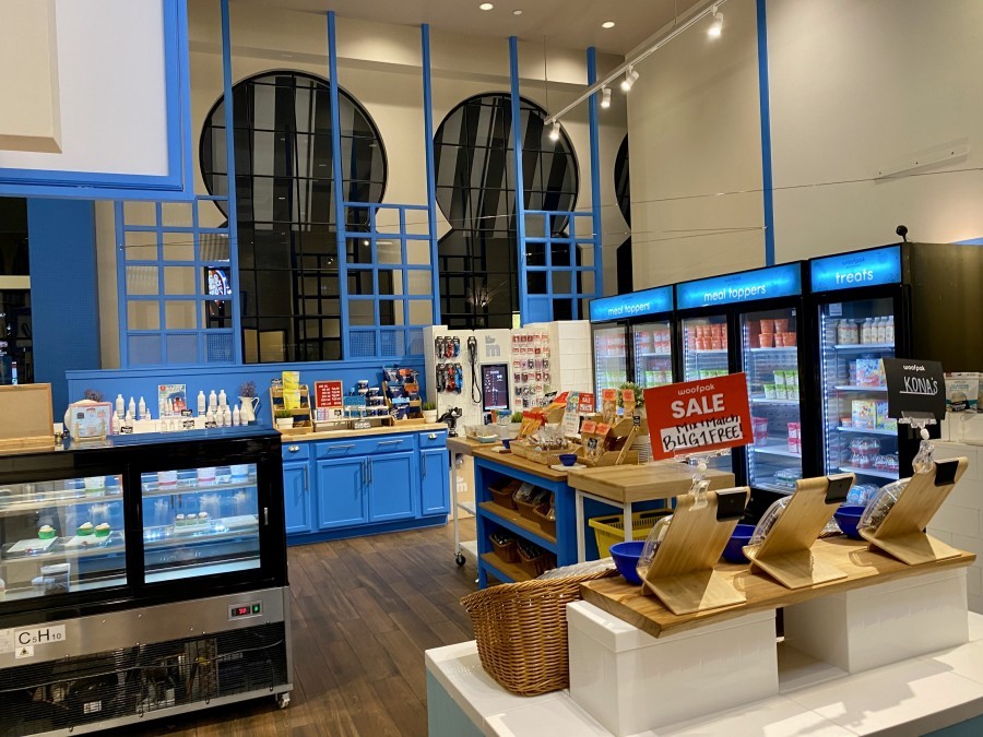 View of the store in Woofpac pet kitchen with blue walls and pet treats in La Jolla California