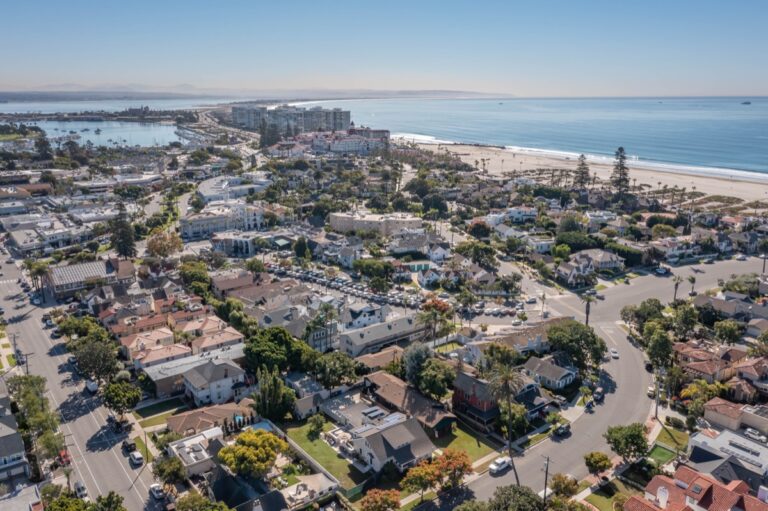 Aerial view of Coronado beach homes and condominiums lining the Pacific Ocean shoreline