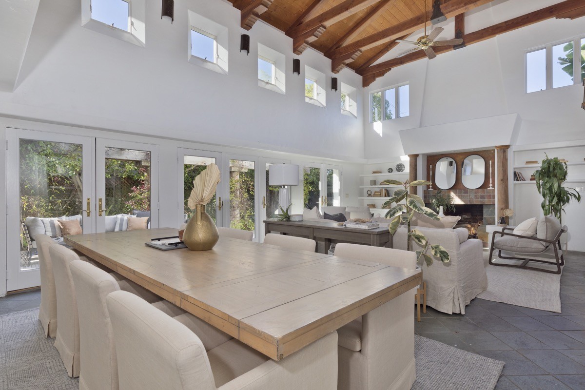 Open concept living and dining room in a luxury Coronado beach house with vaulted wood beam ceilings