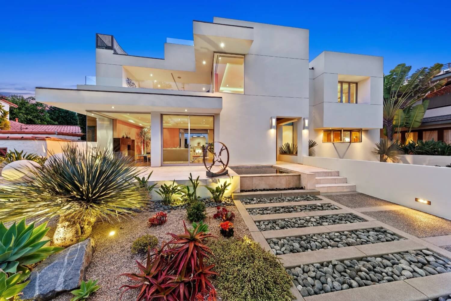 Exterior view of a modern luxury home at dusk, located at 1033 Loma Ave, showcasing elegant architectural design.