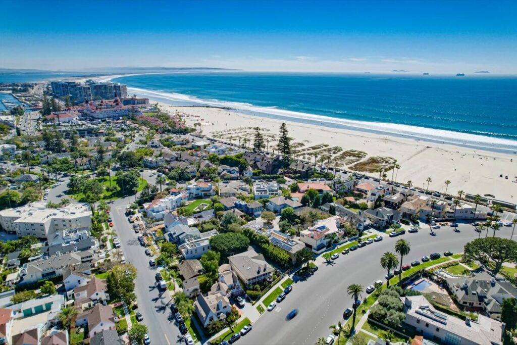 Aerial view of luxury homes on Coronado Island with the expansive beach and ocean in the background.