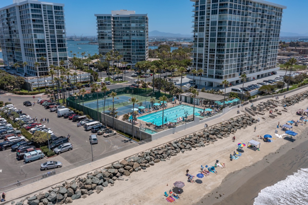 Aerial image of Coronado Shores community condo buildings and amenities including pool and tennis court, courtesy of top Coronado Realtor Whitney Benzian