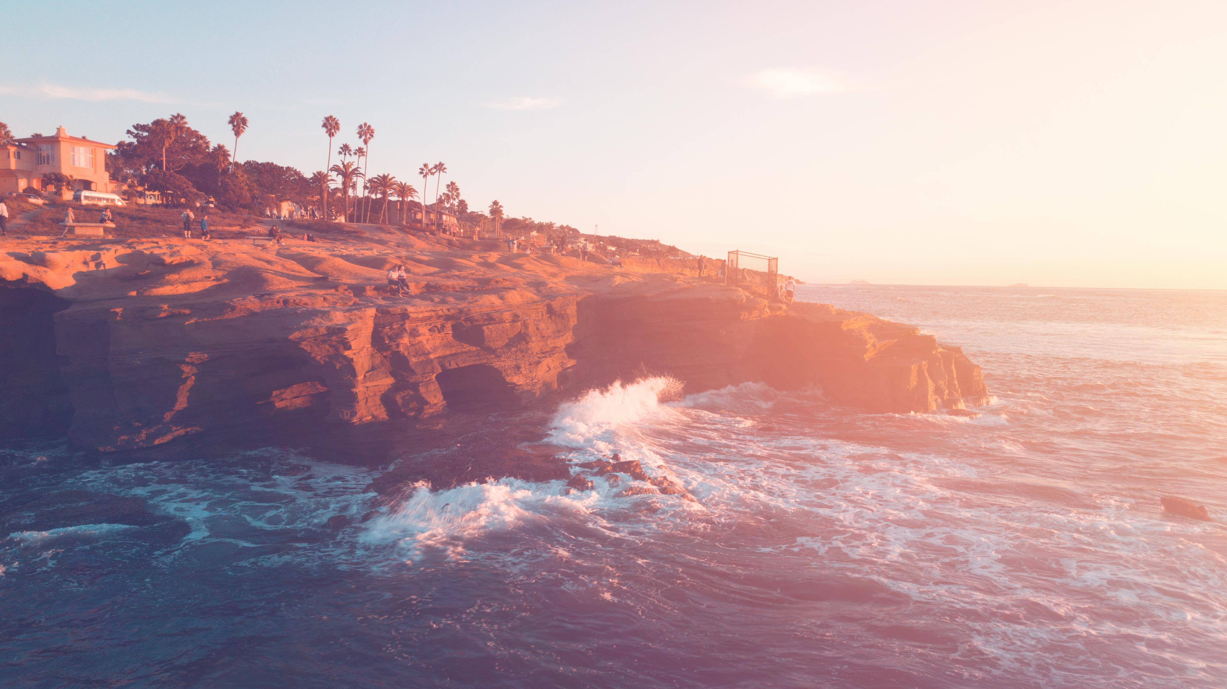 La Jolla coastline with bluffs and crashing waves comparing Coronado real estate by top local agents and realtors