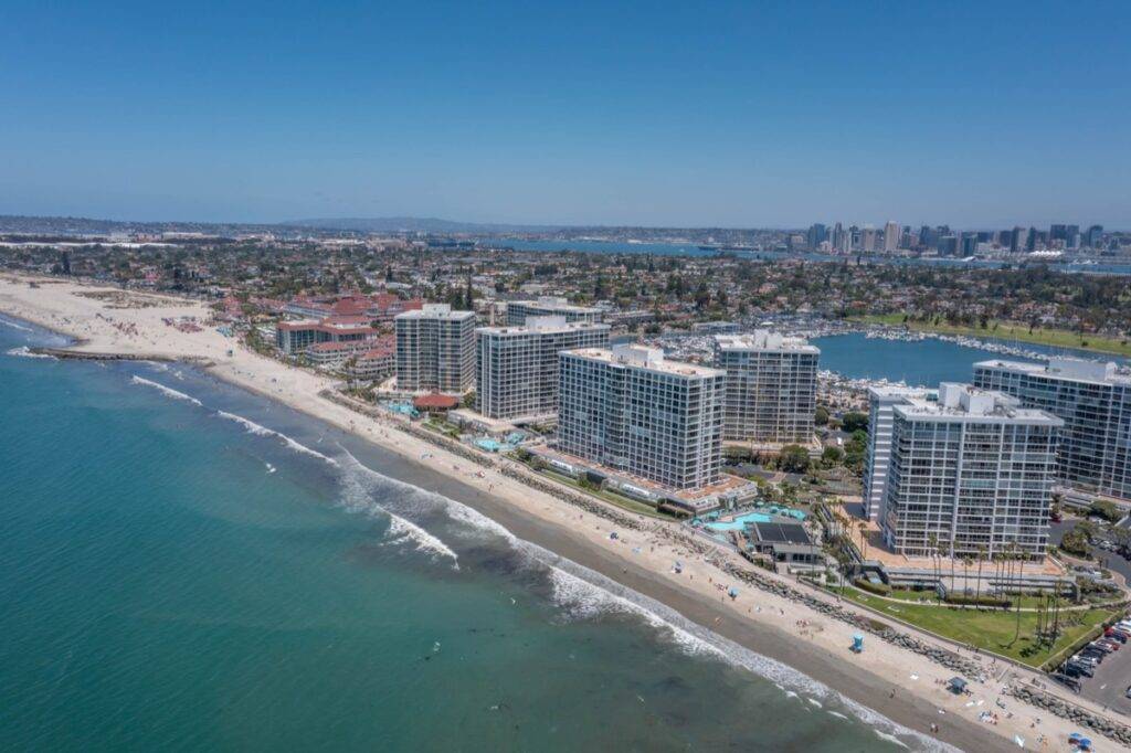 Aerial view of Coronado Shores condominium buildings and the beach, for homebuyers and sellers with the best real estate agents.