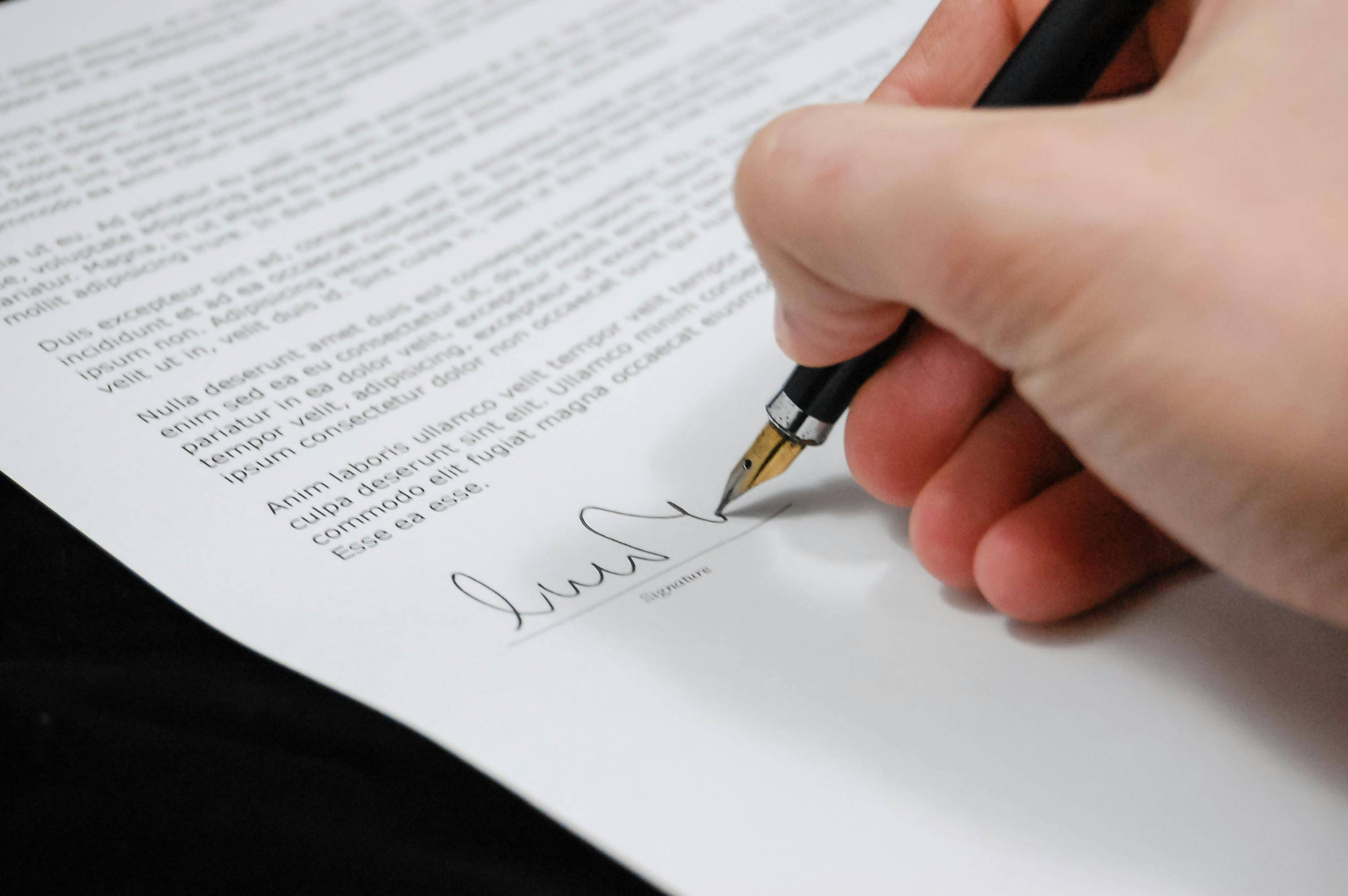 Hand with pen signing a contract representing a buyer offer to purchase a home in Coronado California with top local realtor agent Whitney Benzian