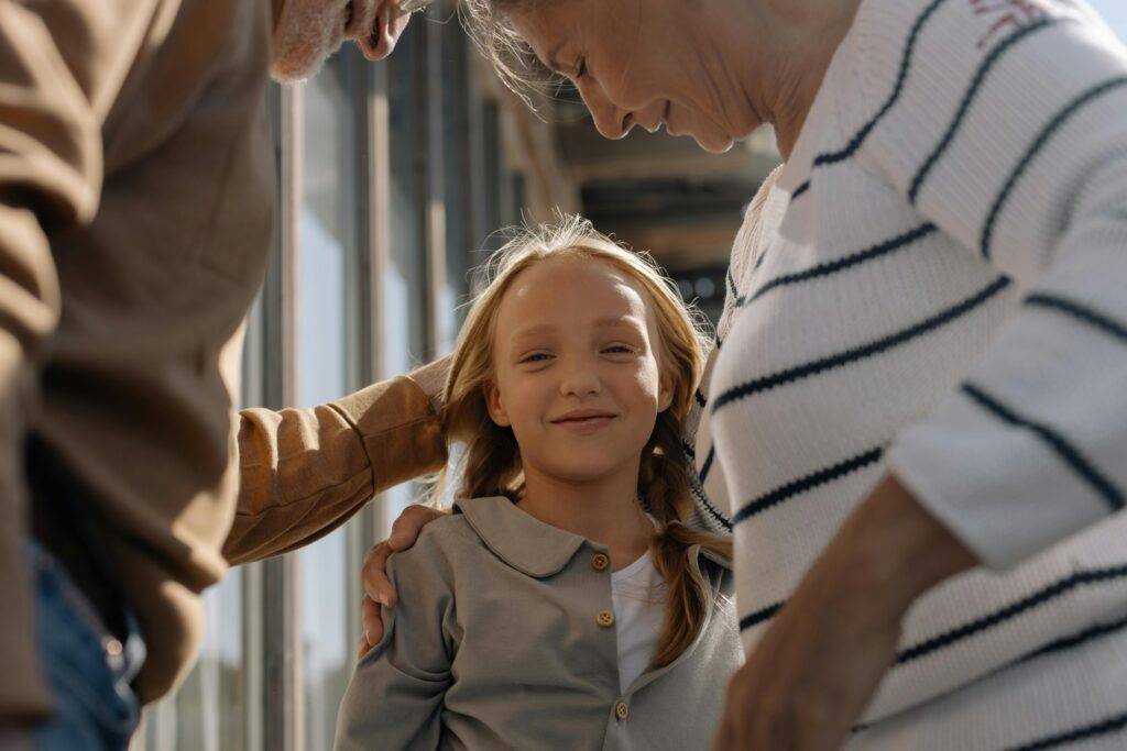 Grandparents with their granddaughter, representing the care of creating a trust for your Coronado home