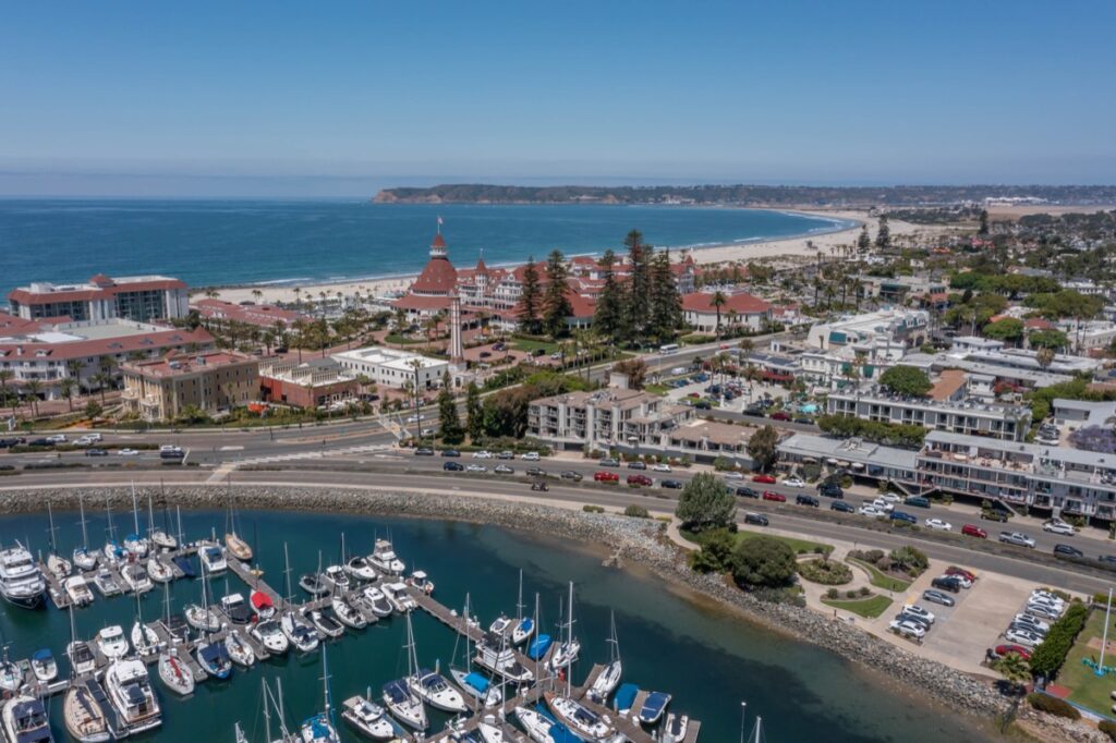 Aerial drone photo of Coronado marina and the Hotel Del Coronado, by the best local luxury real estate agents